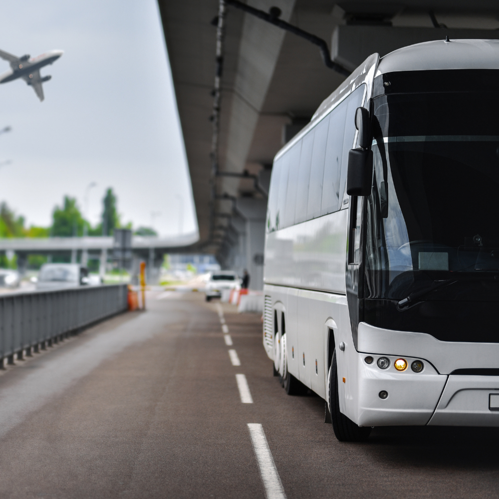 White airport shuttle bus parked at an airport