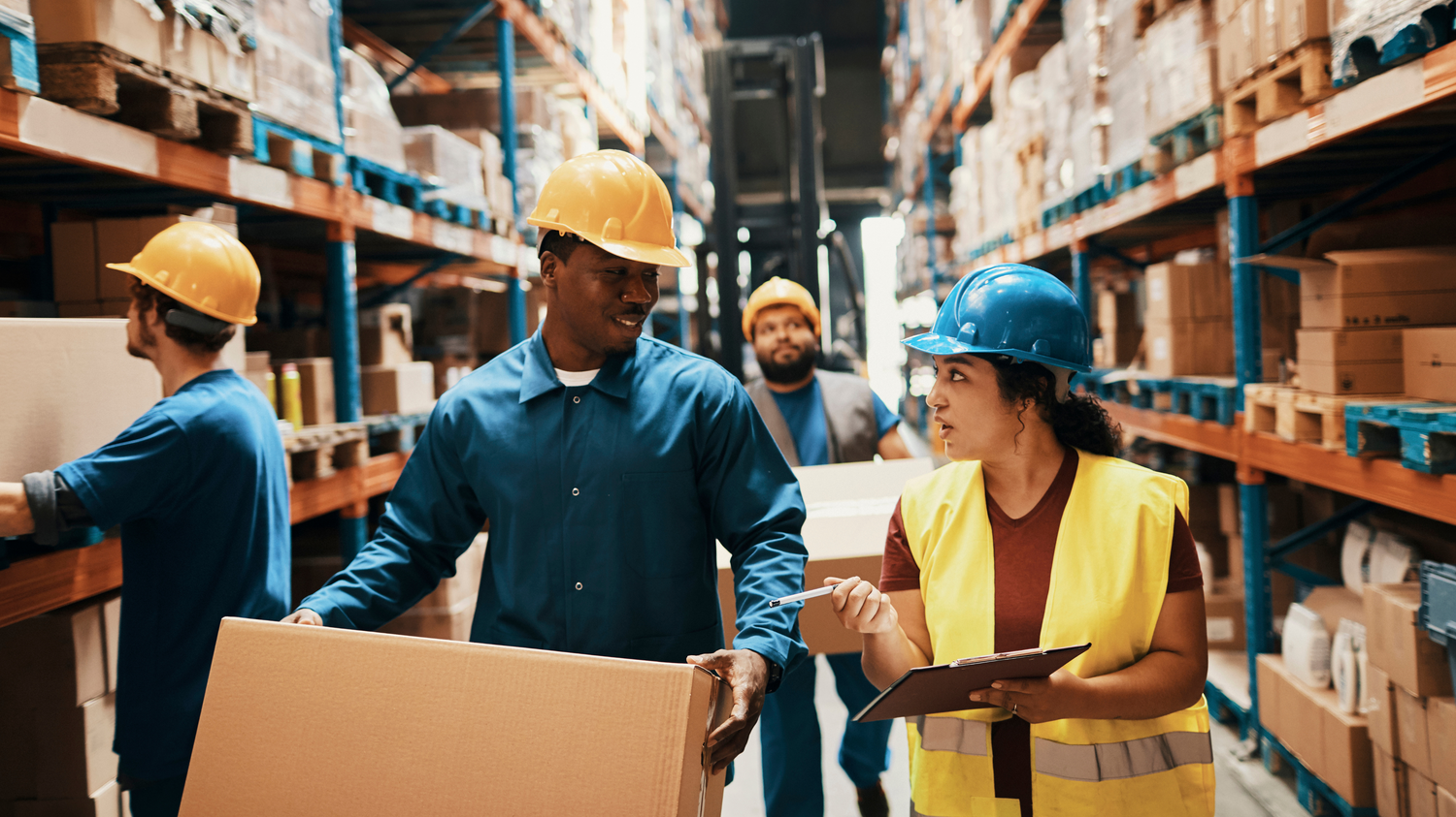 Two warehouse employees having a conversation in a packing facility