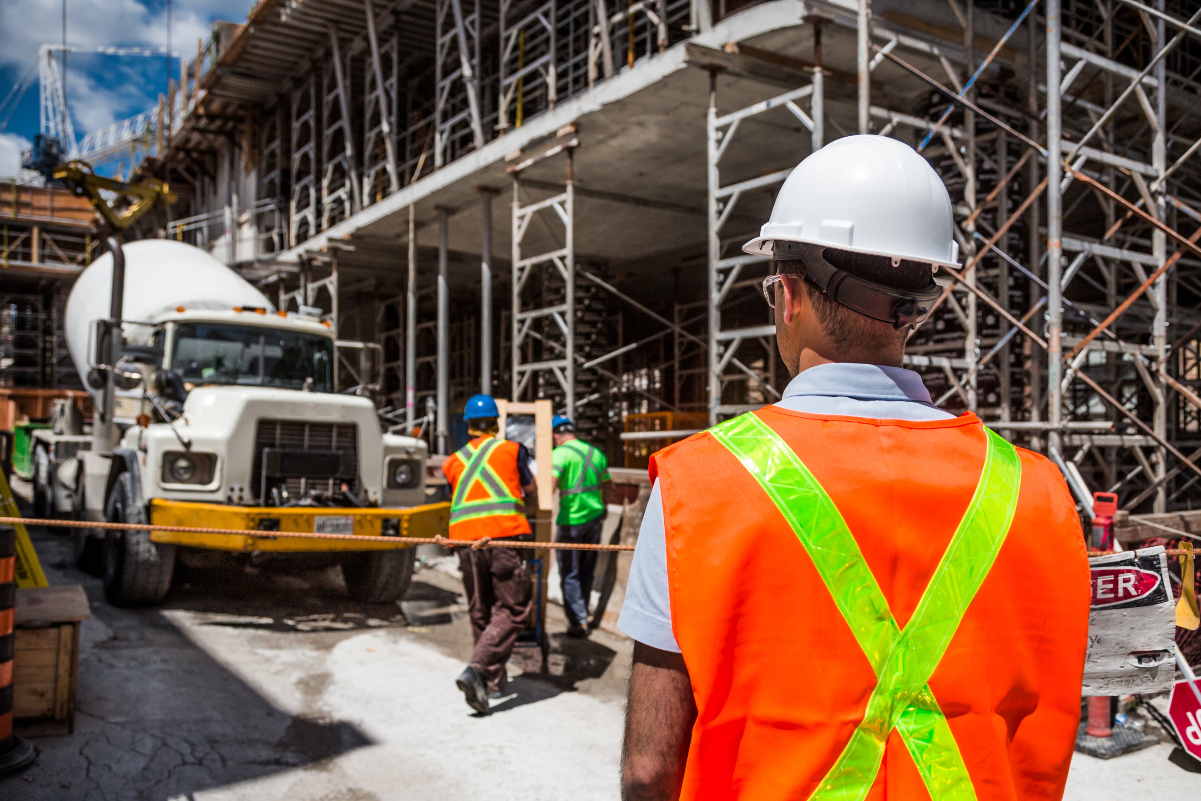 Construction workers with cement surveying a construction site.